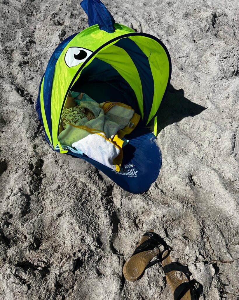 Baby sleeping on a beach vacation with kids. 