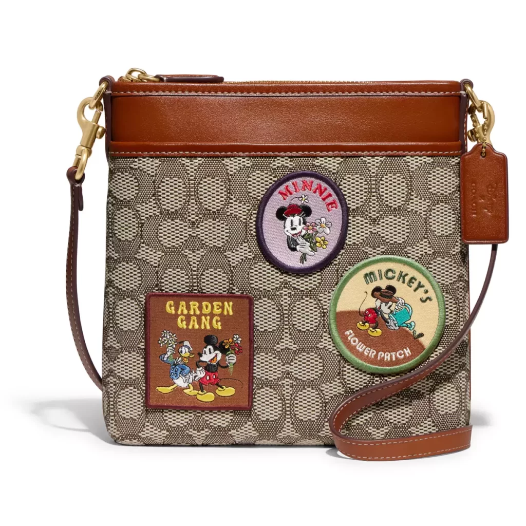 Coach purse with Disney patches on it