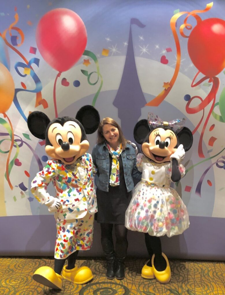 Melissa, a travel agent, posing with Mickey and Minnie Mouse 